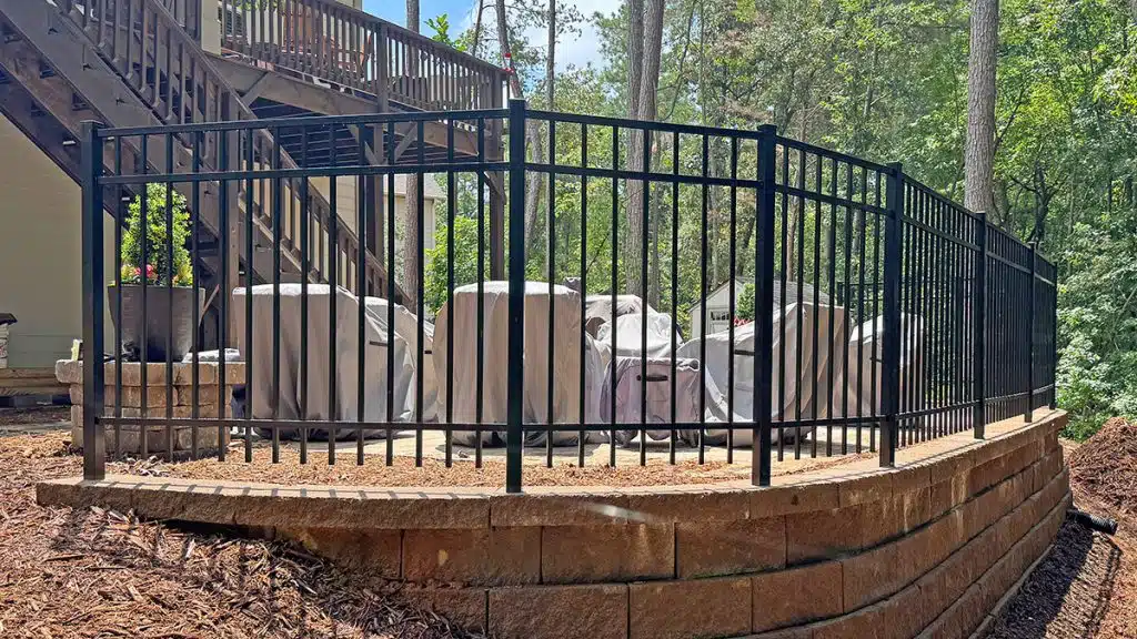 Ornamental aluminum fence installed on curved retaining wall Ellijay GA