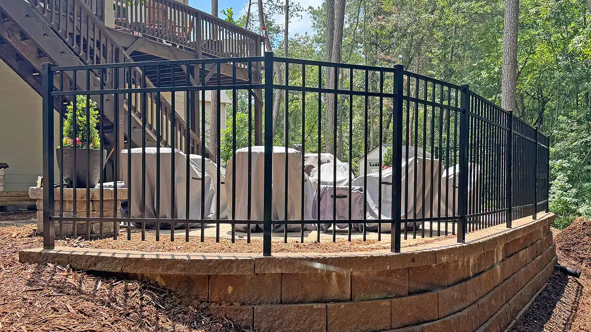 Ornamental aluminum fence installed on curved retaining wall Ellijay GA