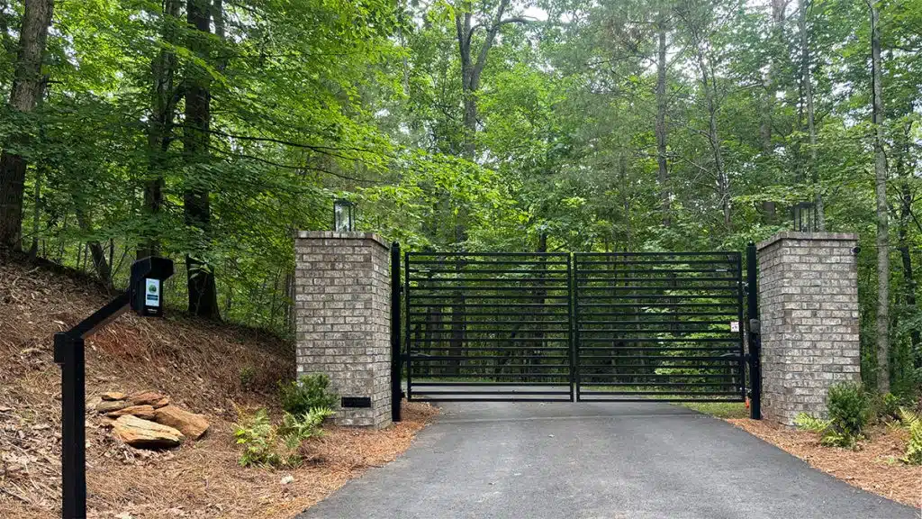 ALEKO MILAN dual swing gate between brick columns with a CAPXS intercom pedestal at a Jasper, GA property.