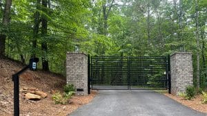 ALEKO MILAN dual swing gate between brick columns with a CAPXS intercom pedestal at a Jasper, GA property.