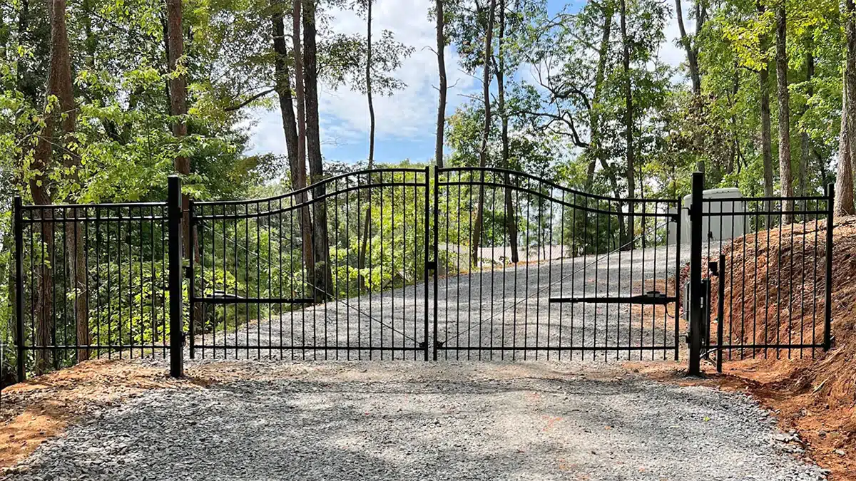 Custom steel driveway gate and side fence panels at Blue Ridge home