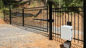 Custom 20-foot steel automatic driveway exit gate installed by North Georgia Fence Company at Glamp Blue Ridge, GA.